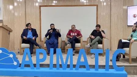 Sohaib Tariq moderating a five-person panel on stage in front of a large APIMatic sign in Islamabad